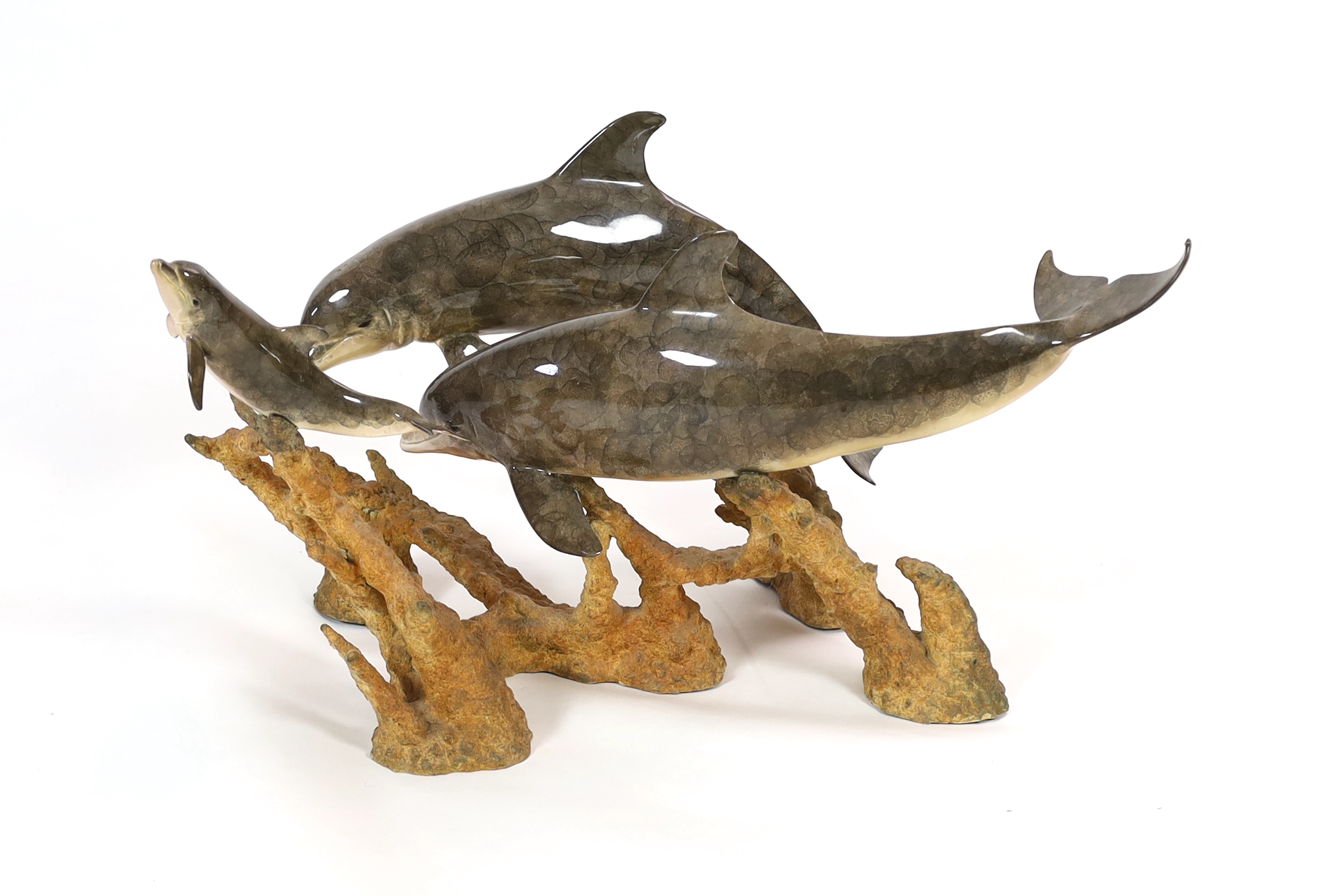 Robert Wyland (American, b.1956), a patinated bronze group 'Dolphin Reef', 81cm long, 53cm deep, 45.5cm high, comes with a plate glass oval top, 130 x 81cm